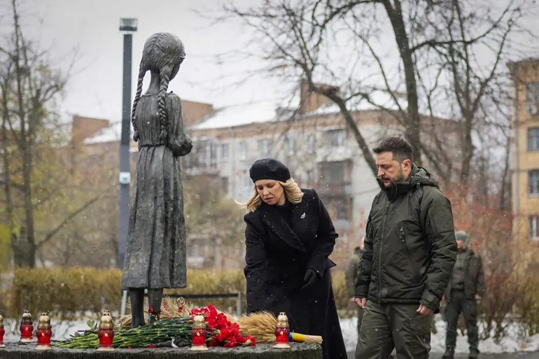 In this photo provided by the Ukrainian Presidential Press Office, Ukrainian President Volodymyr Zelenskyy and his wife Olena pay their tribute at a monument to victims of the Holodomor, Great Famine, that killed millions in the 1930's, in Kyiv, Ukraine, Saturday, Nov. 23, 2024. (Ukrainian Presidential Press Office via AP)