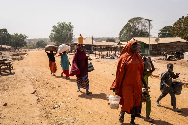 Residents carry their belongings as they flee the area following the attack in Woro, Kwara State, on February 5, 2026.